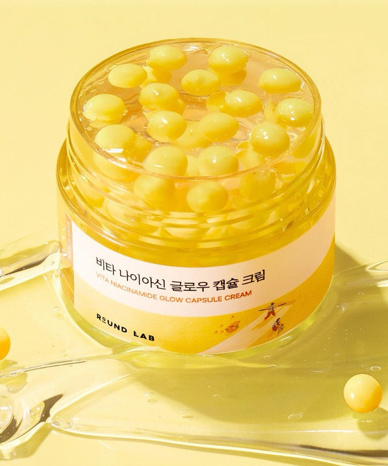 ROUND LAB Vita Niacin Glow Capsule Cream 50ml on yellow background with capsule details.