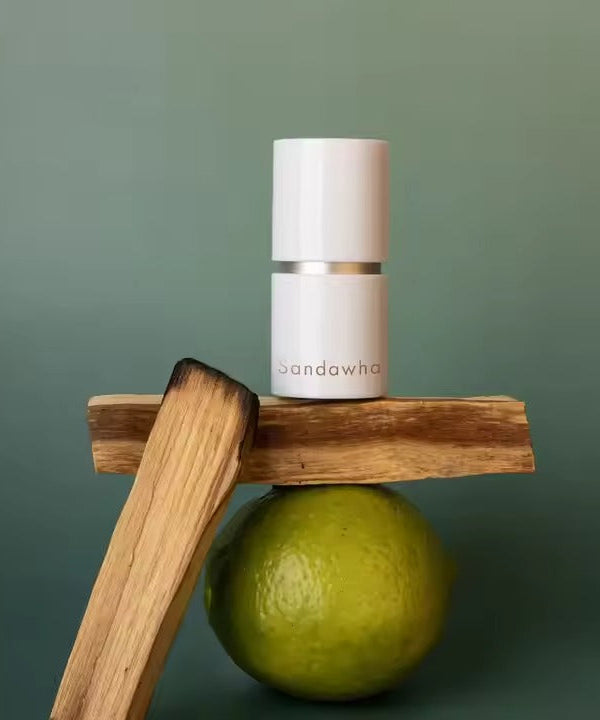 SANDAWHA Remember Perfume Balm 5.6g showcased with a natural backdrop including wood and a green lime.