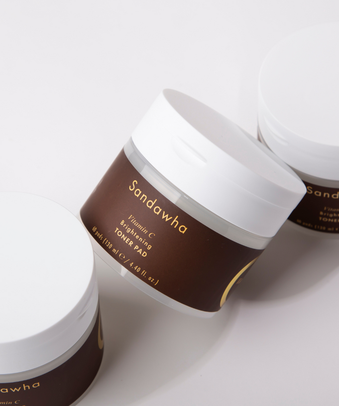SANDAWHA Vitamin C Whitening Toner pad 60 Sheets in brown and white jars on a white surface