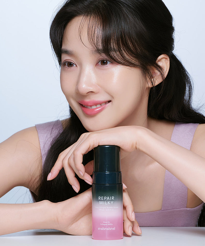 Woman holding SHAISHAISHAI Repair Milky Urea Glow Bubble Serum 100ml bottle, showcasing skincare product.