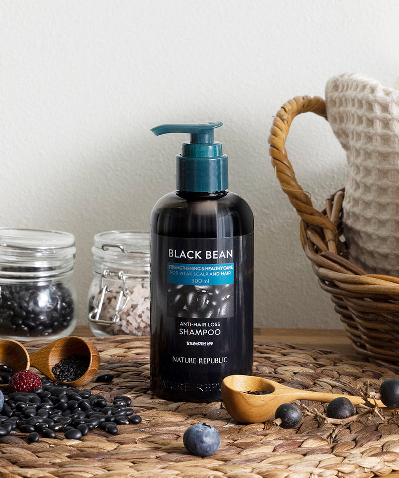 NATURE REPUBLIC Black Bean Anti Hair Loss Shampoo bottle on table with black beans and fabric basket