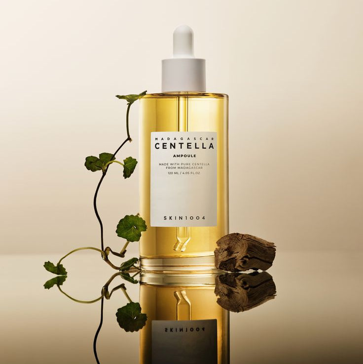 SKIN1004 Madagascar Centella Ampoule 100ml bottle with plant on reflective surface.