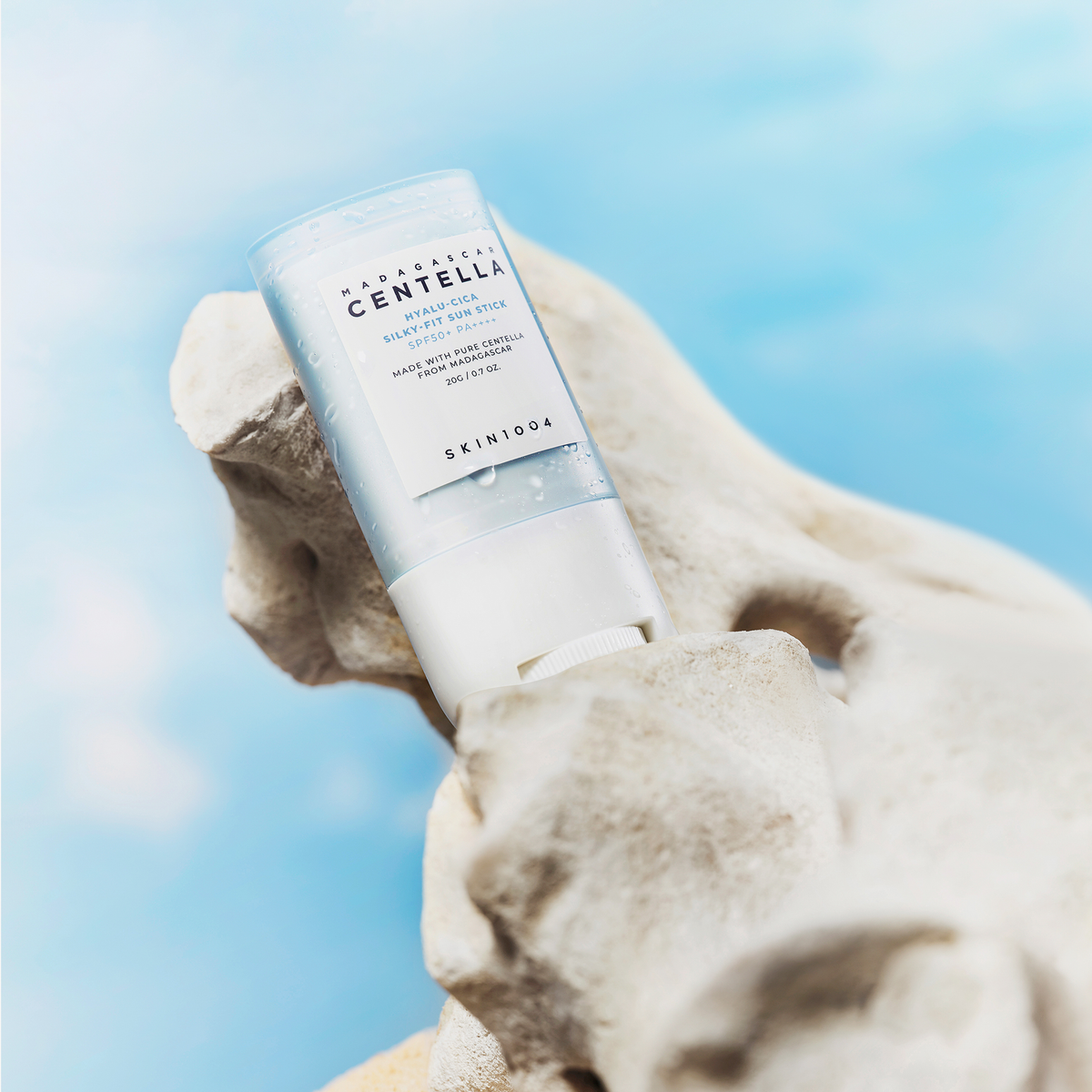 SKIN1004 Madagascar Centella Hyalu-Cica Silky Fit Sun Stick 20g on rock with blue sky background