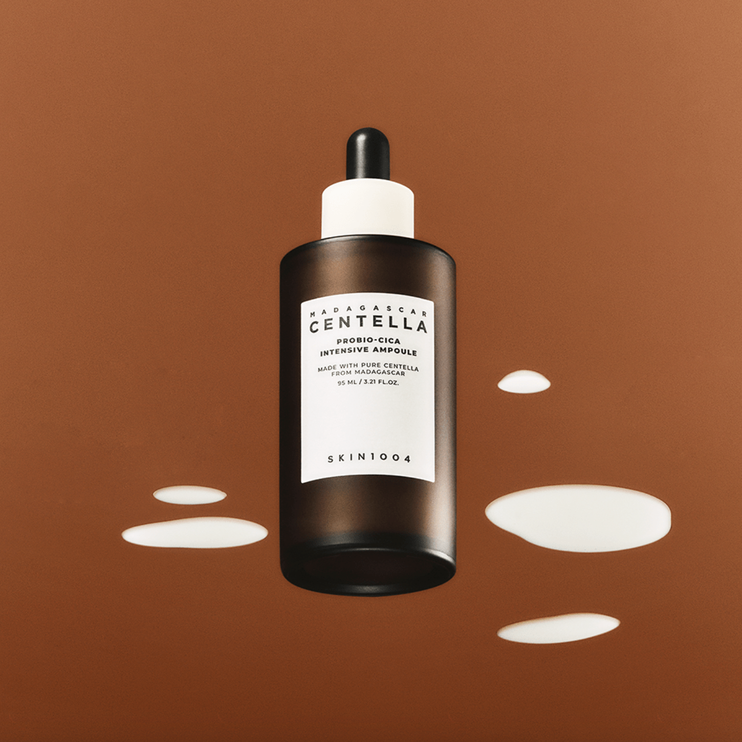 SKIN1004 Madagascar Centella Probio-cica Intensive Ampoule 95ml bottle on brown background with liquid drops