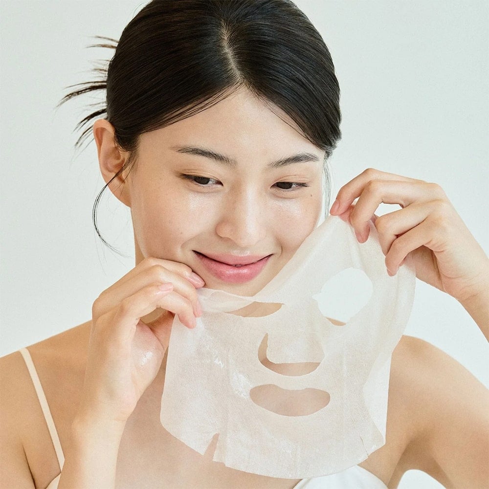 Woman applying SKIN1004 Madagascar Centella Tone Brightening Glow Mask 25ml [5 sheets]