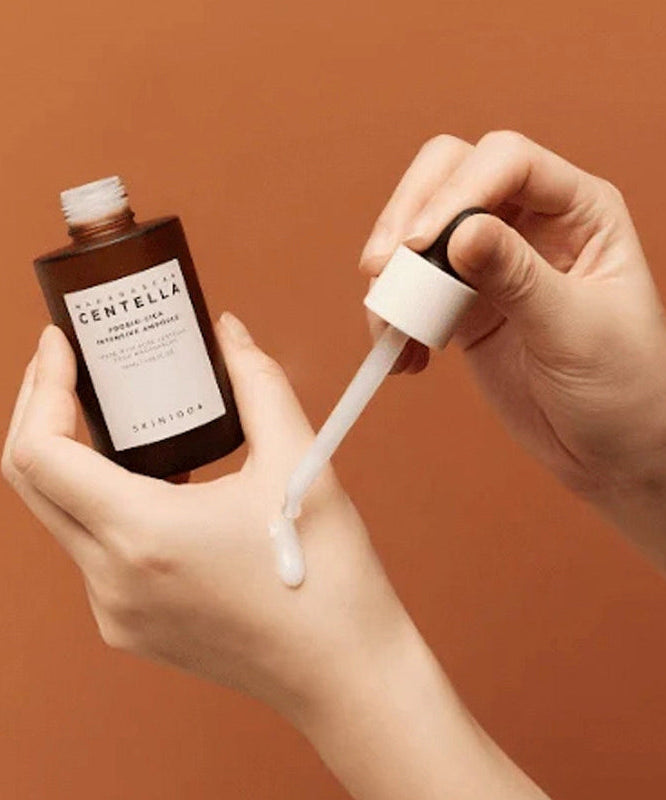 Applying SKIN1004 Madagascar Centella Probio-cica Intensive Ampoule 50ml on skin with dropper.
