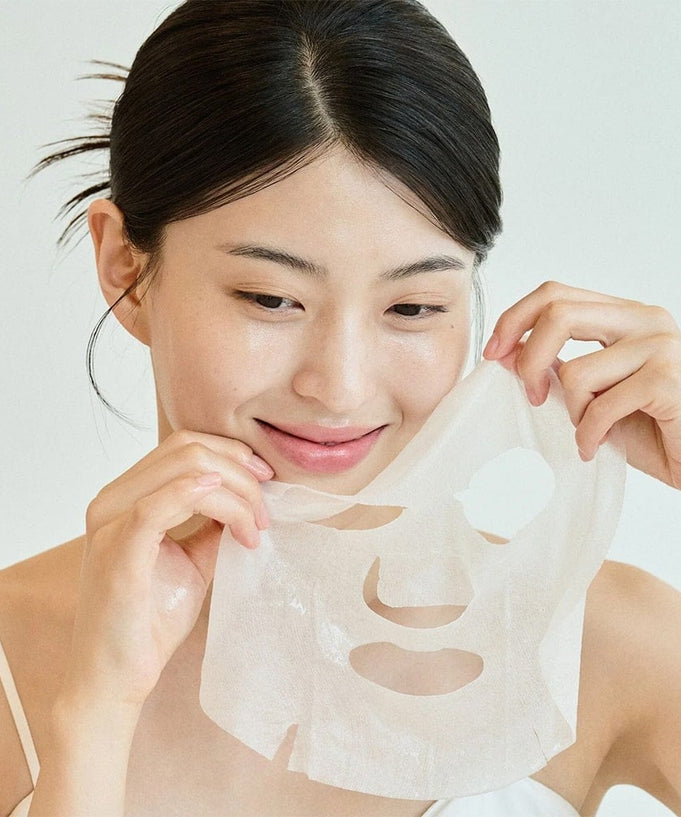 Woman applying SKIN1004 Madagascar Centella Tone Brightening Glow Mask 25ml [5 sheets]