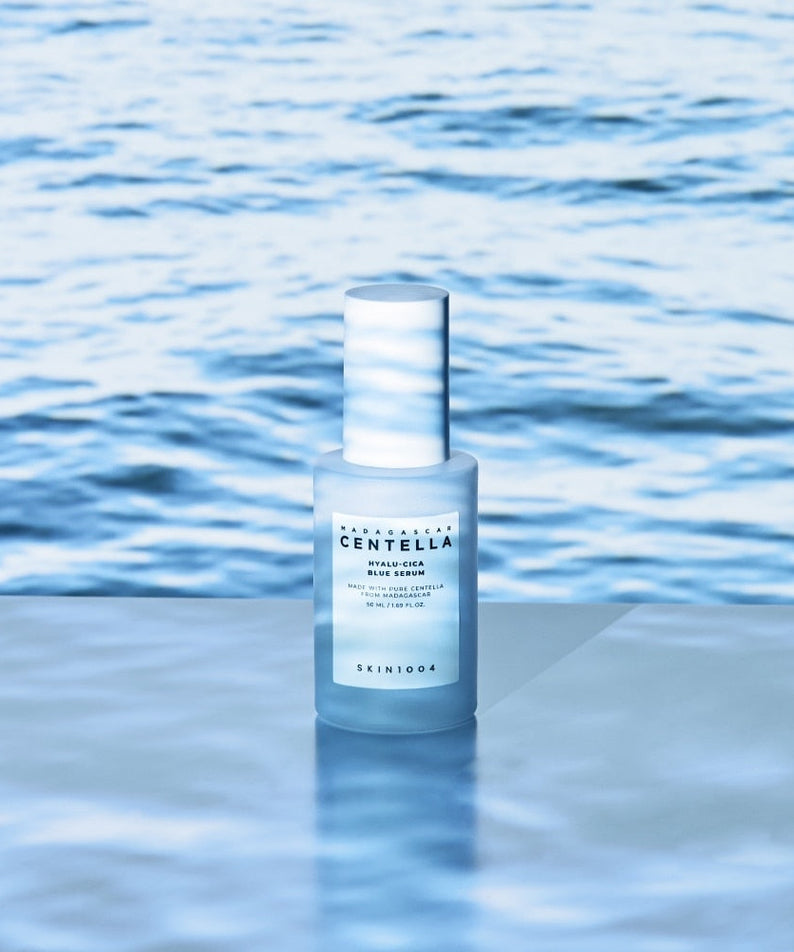 SKIN1004 Madagascar Centella Hyalu-Cica Blue Serum 50ml on a reflective surface with ocean background