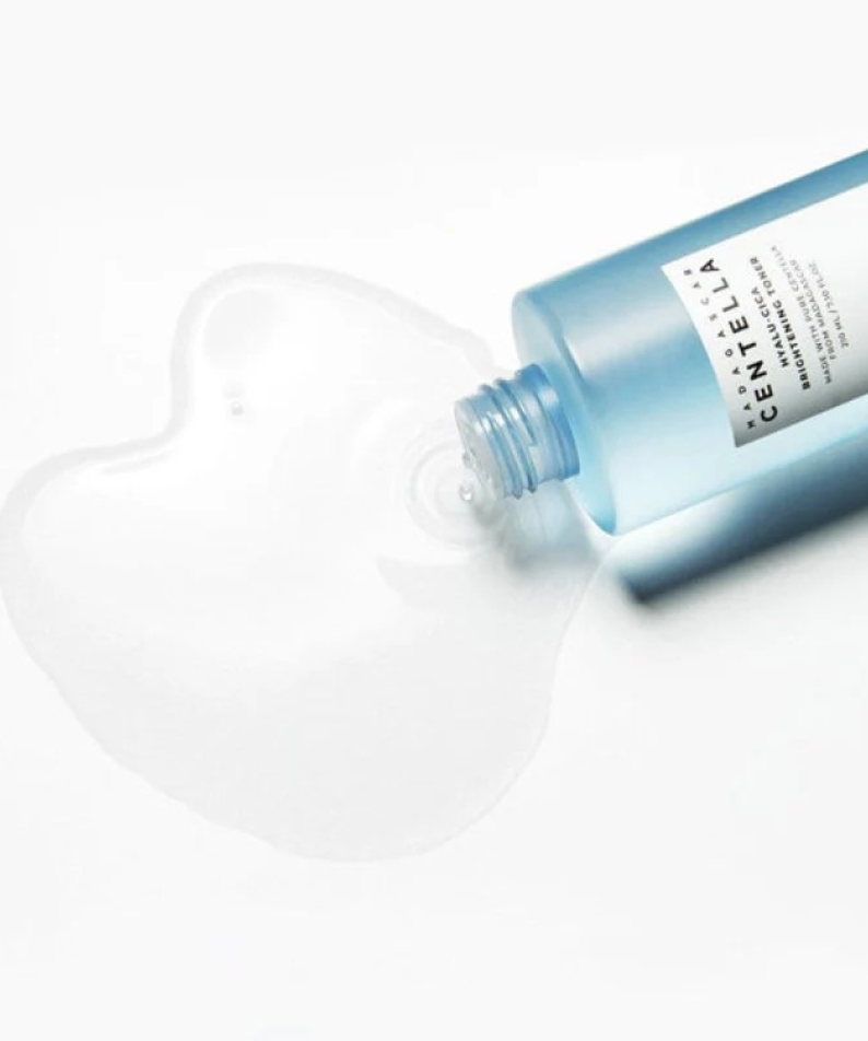 SKIN1004 Madagascar Centella Hyalu-Cica Radiance Toner 210ml bottle with spilled toner on white background.