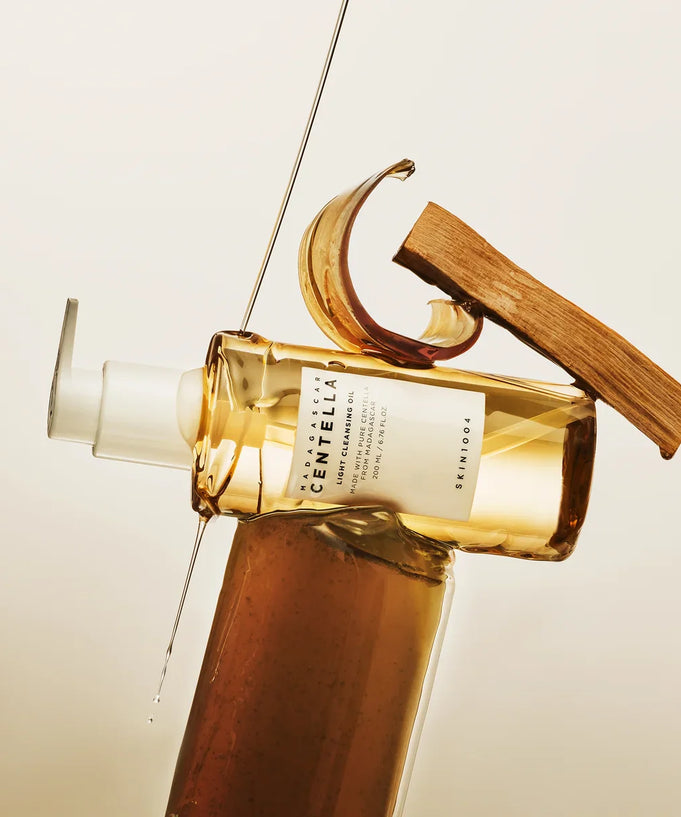 Bottle of SKIN1004 Madagascar Centella Light Cleansing Oil 200ml with elegant design display on neutral background.