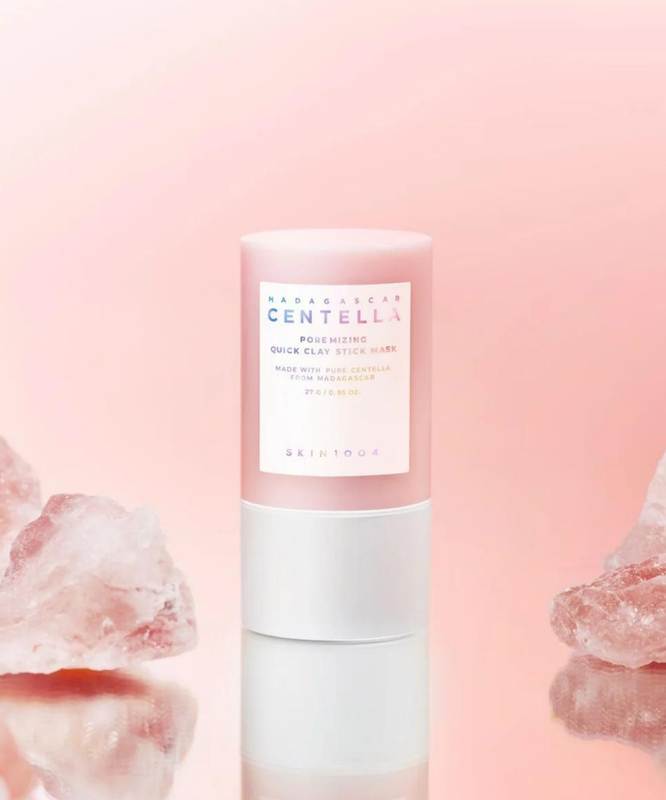 SKIN1004 Madagascar Centella Poremising Quick Clay Stick Mask 27g on a pink background with rose quartz crystals.