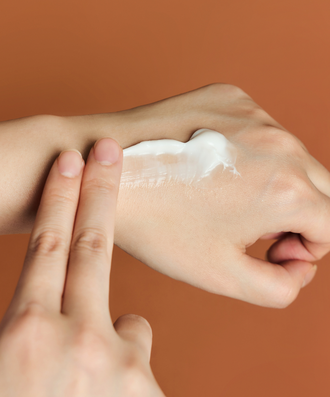 Person applying SKIN1004 Madagascar Centella Probio-cica Enrich Cream 50ml on hand for skincare.