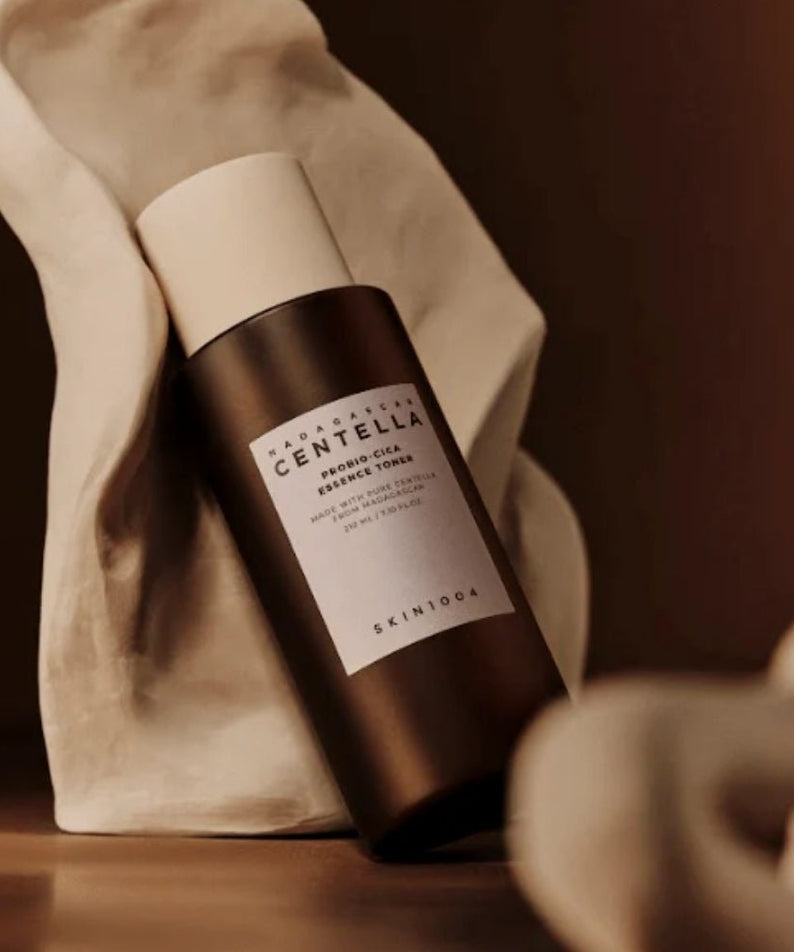 SKIN1004 Madagascar Centella Probio-cica Essence Toner 210ml bottle on display with elegant fabric backdrop