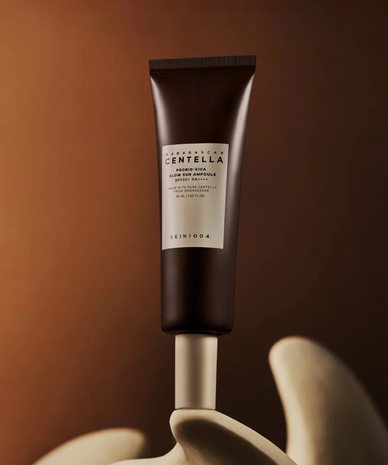 SKIN1004 Madagascar Centella Probio-cica Glow Sun Ampoule 50ml on display against a warm backdrop