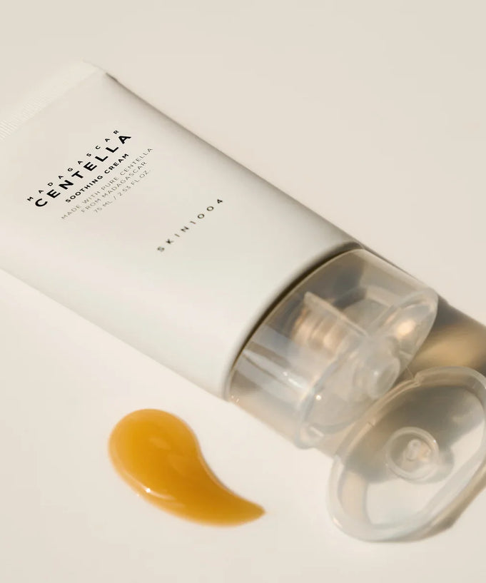 Tube of SKIN1004 Madagascar Centella Soothing Cream 75ml with cream sample next to it on a light background.