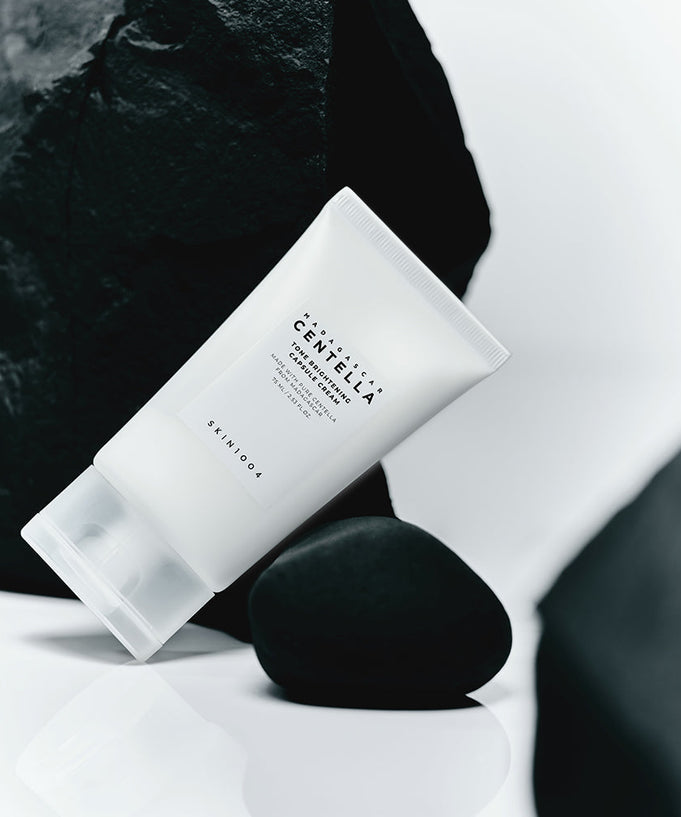 SKIN1004 Madagascar Centella Tone Brightening Capsule Cream 75ml product tube on a minimalist rock background.