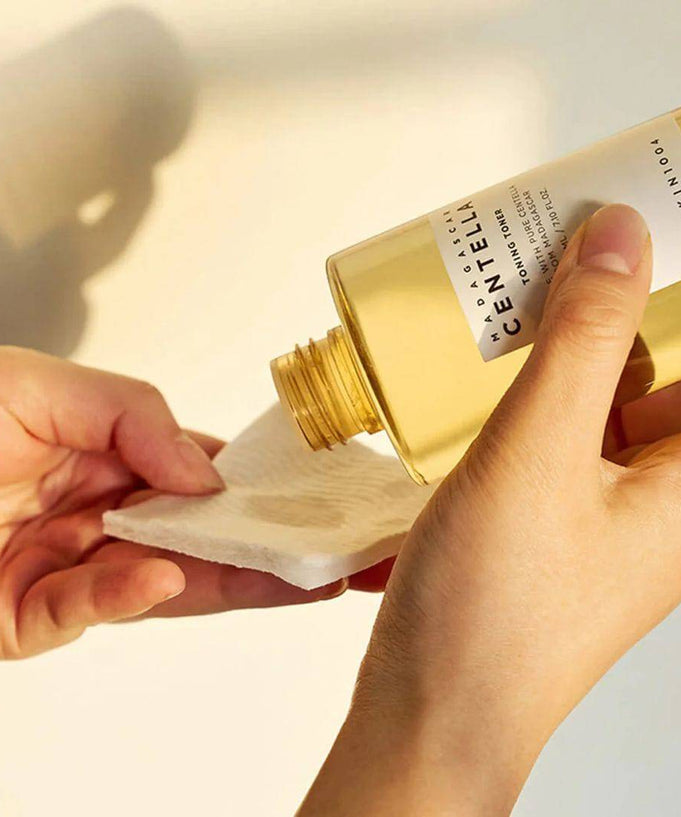 Pouring SKIN1004 Madagascar Centella Toning Toner 400ml onto a cotton pad.