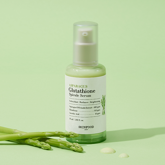 SKINFOOD Asparagus Glutathione Spicule Serum 50ml bottle on green background with asparagus