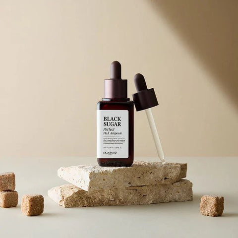 SKINFOOD Black Sugar Perfect PHA Ampoule 50ml displayed with dropper on stone surface