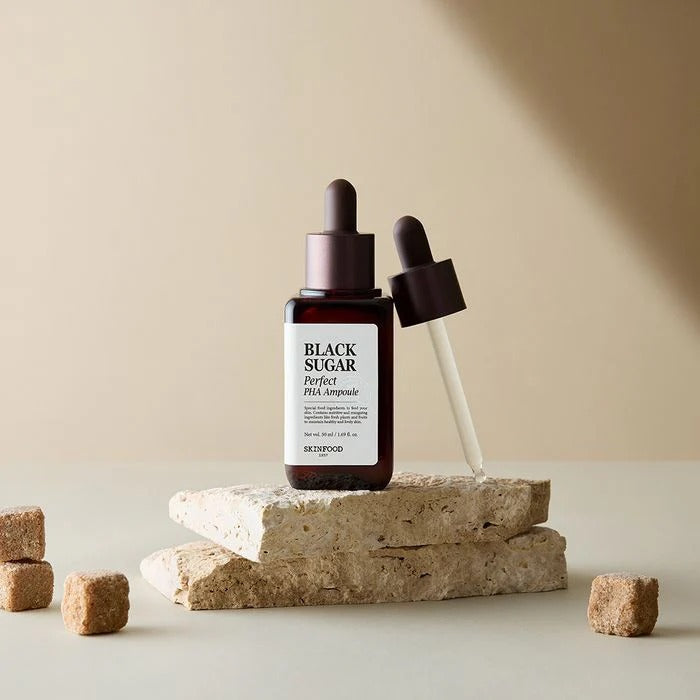 SKINFOOD Black Sugar Perfect PHA Ampoule 50ml displayed with dropper on stone surface