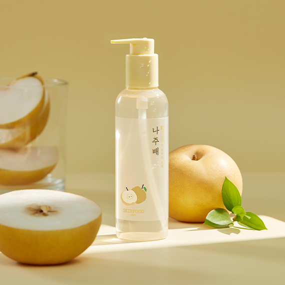 SKINFOOD Naju Bae Deep Cleansing Oil bottle with pears in a bright setting, showcasing skincare product.