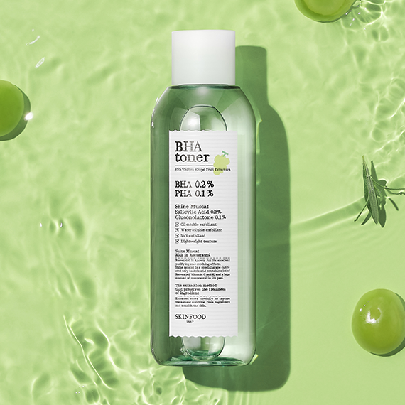 Bottle of SKINFOOD Shine Muscat BHA Toner 200ml on a green background with muscat grapes.