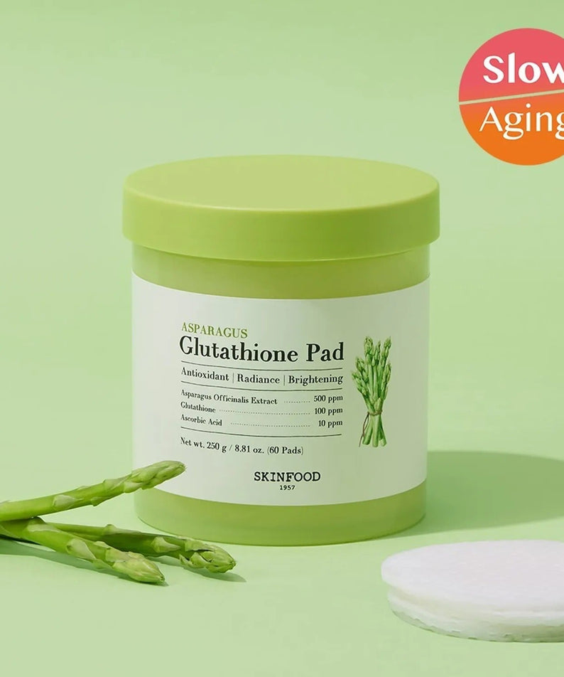 SKINFOOD Asparagus Glutathione Pad (60 Pads) with slow aging benefits and fresh asparagus on a green background