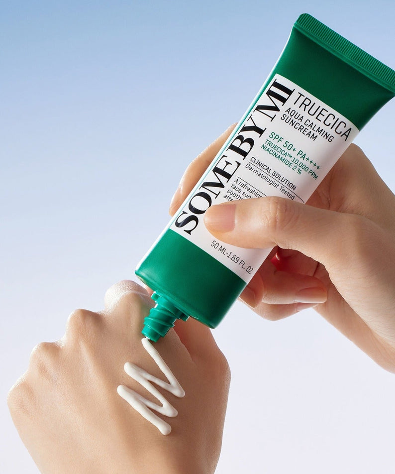 Applying SOME BY MI Truecica Aqua Calming Sun Cream 50ml on hand with cream texture displayed.