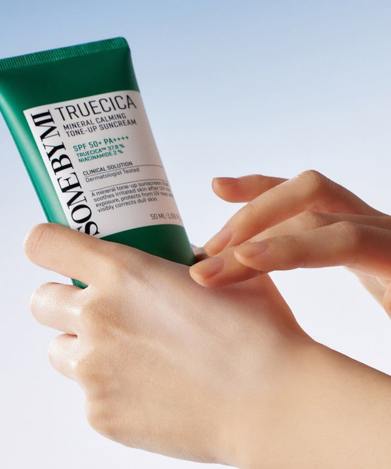 Hands holding SOME BY MI Truecica Weaponless Calming Tone Up Sun Cream 50ml