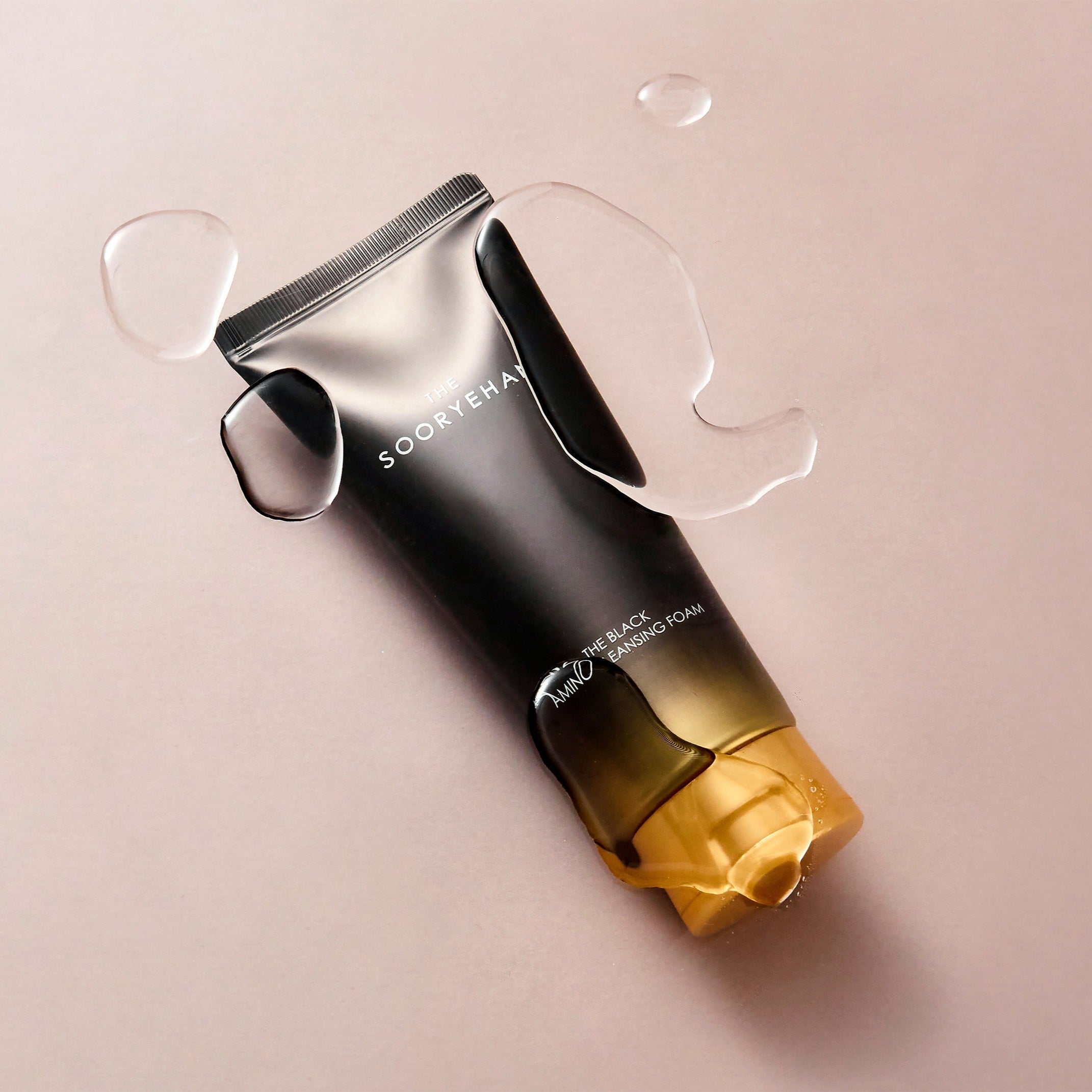 SOORYEHAN The Black Amino Cleansing Foam 150ml tube on a wet surface, showcasing premium skincare packaging design.