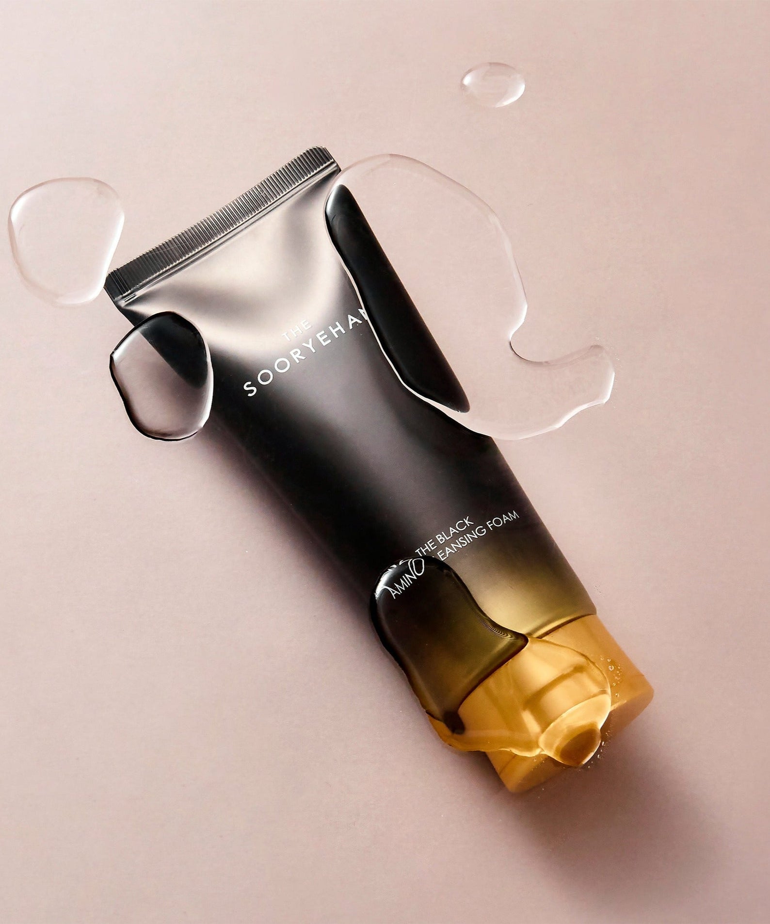 SOORYEHAN The Black Amino Cleansing Foam 150ml tube on a wet surface, showcasing premium skincare packaging design.