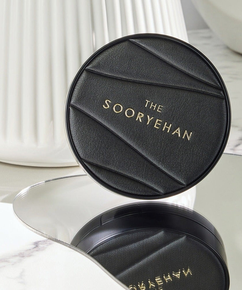 SOORYEHAN The Black Tension Fit Mesh Cushion 13g on a marble surface, reflecting elegance and luxury in design.