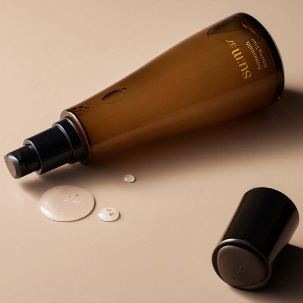 SU:M37 Fermentalift boosting toner 150ml bottle with open cap, showcasing product texture on a beige background