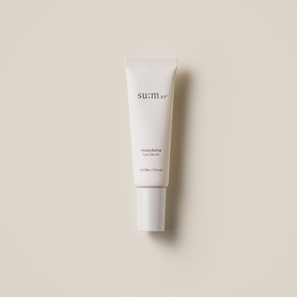 SU:M37 Microactive Sun Serum 50ml in white tube with SPF50+ protection on beige background.