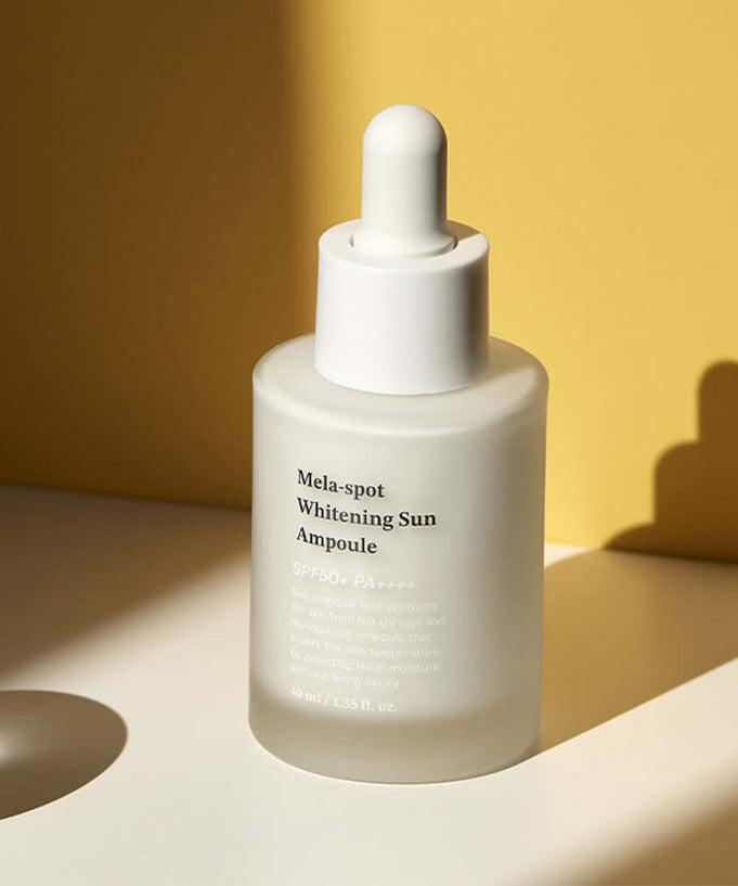 SUNGBOON EDITOR Mela Spot Whitening Sun Ampoule 40ml product bottle against a yellow background for skincare routine enhancement.