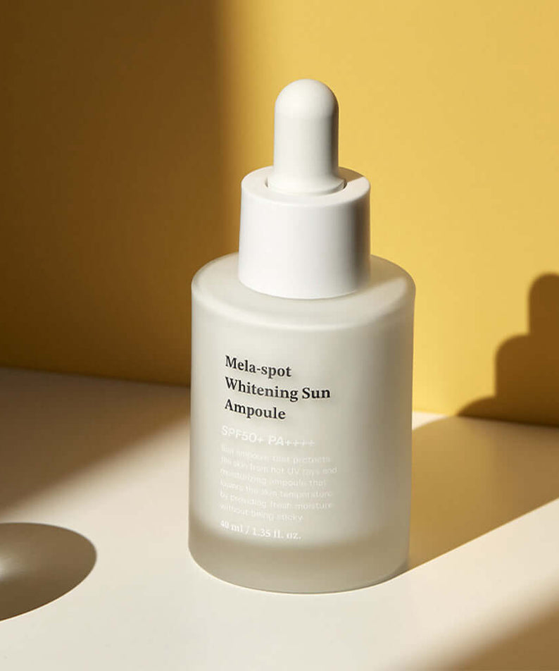 SUNGBOON EDITOR Mela Spot Whitening Sun Ampoule 40ml product bottle against a yellow background for skincare routine enhancement.