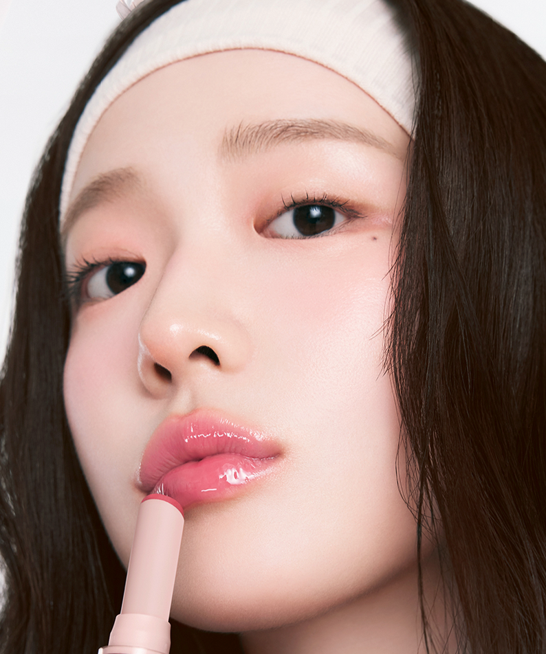 Person applying HOLIKA HOLIKA Glow Rise Balm with a glistening finish, showcasing one of the 8 colors in a close-up view.