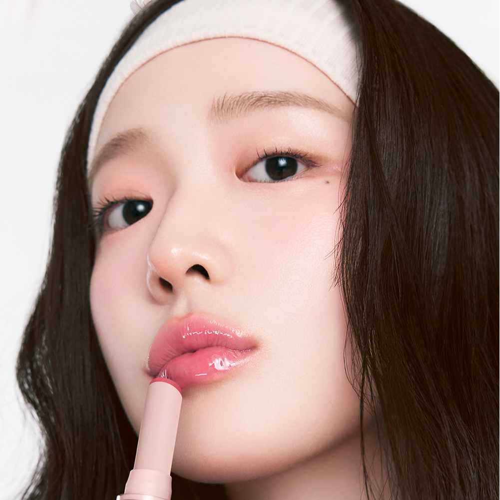 Person applying HOLIKA HOLIKA Glow Rise Balm with a glistening finish, showcasing one of the 8 colors in a close-up view.