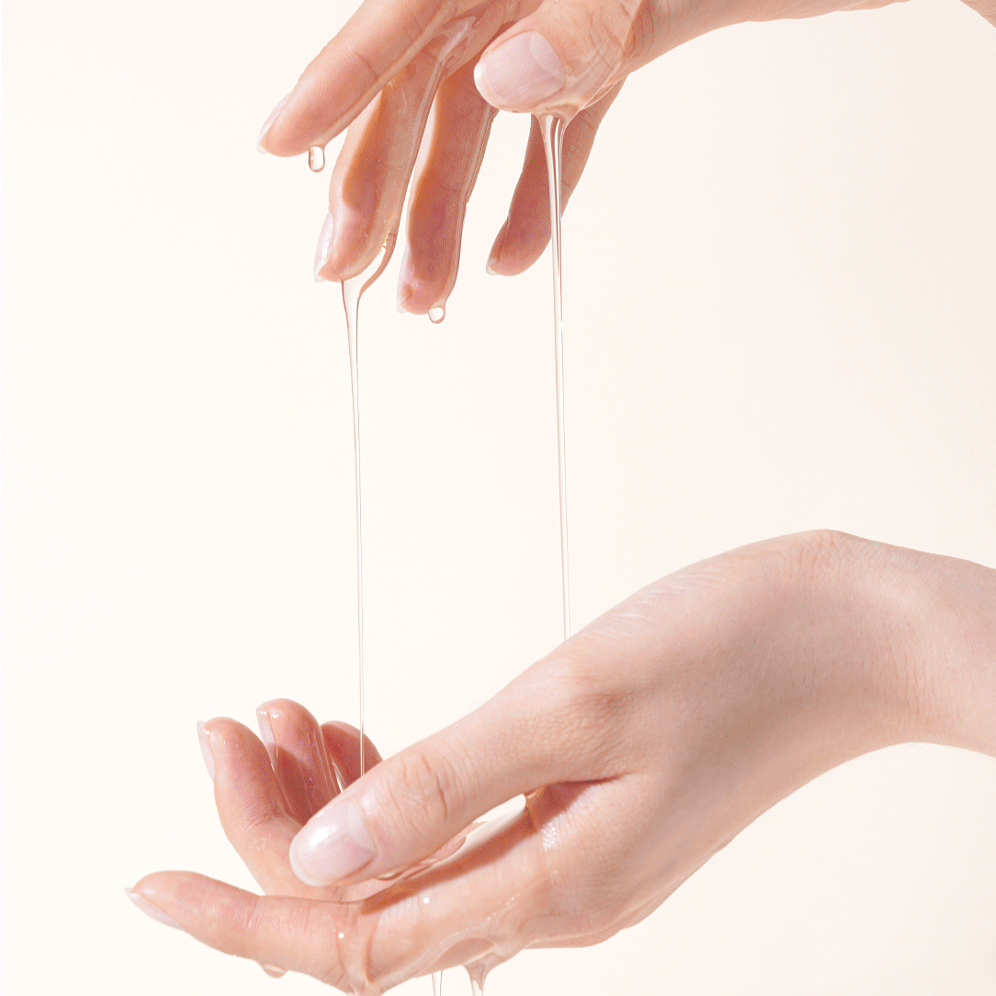 Hands applying HOLIKA HOLIKA Gold Kiwi Vita C+ Brightening Cleansing Oil 200ml with dripping texture for skincare routine.