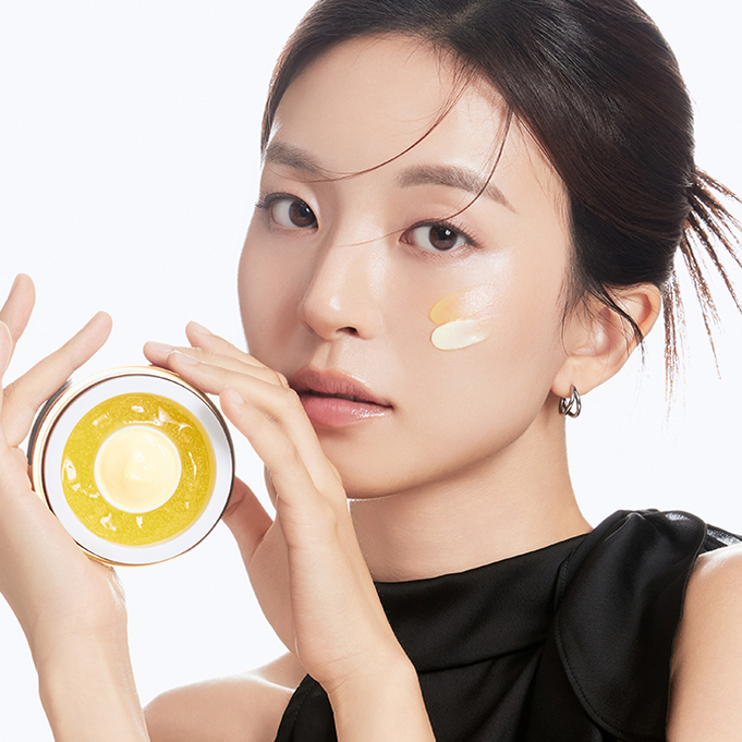Woman holding DR.CEURACLE Pure VC Mellight A-Tinol Cream 70g next to her face, showcasing skincare product application on cheek.