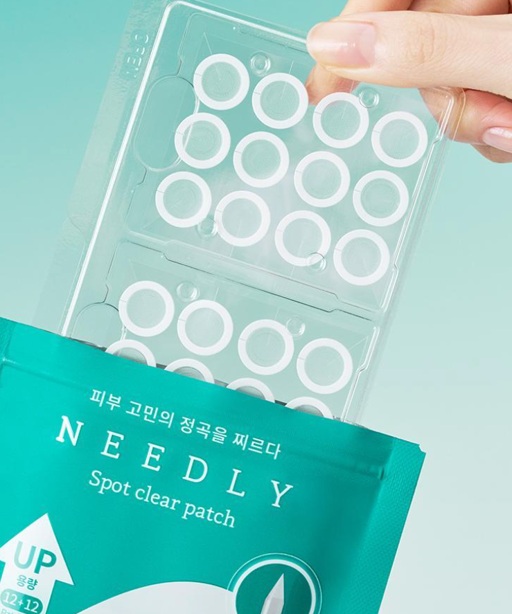 Hand holding NEEDLY Patch Spot Clear 12 Patches packaging against teal background, showcasing the acne treatment patches.
