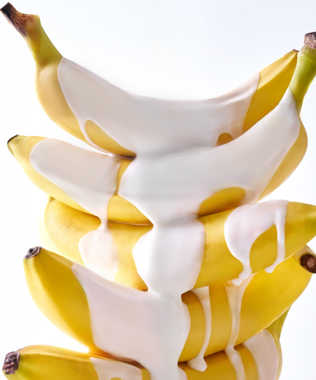 Fresh bananas covered in creamy lotion, concept related to UNLEASHIA Niacinamide Banana Sun Serum 40ml skincare product.