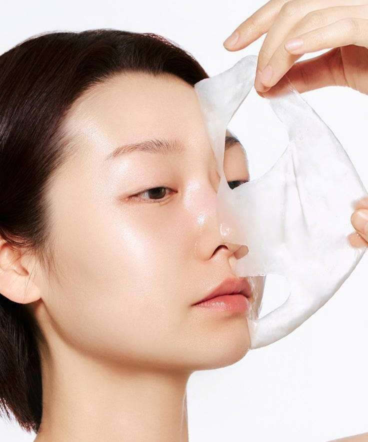 Model applying ABIB Blemish Collagen Wrapping Mask Glutathione Film 100ml for skincare routine.