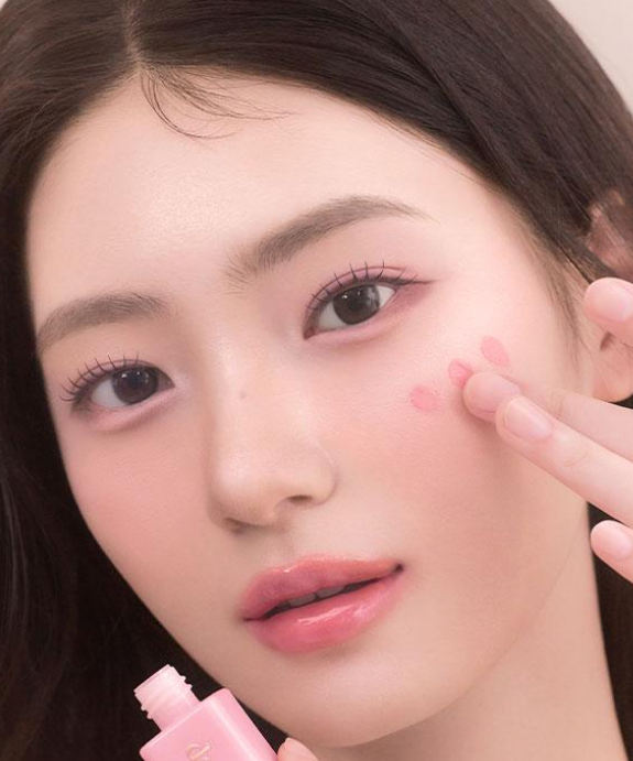 Woman applying DASIQUE Silky Veil Blush on cheeks for a natural rosy glow.