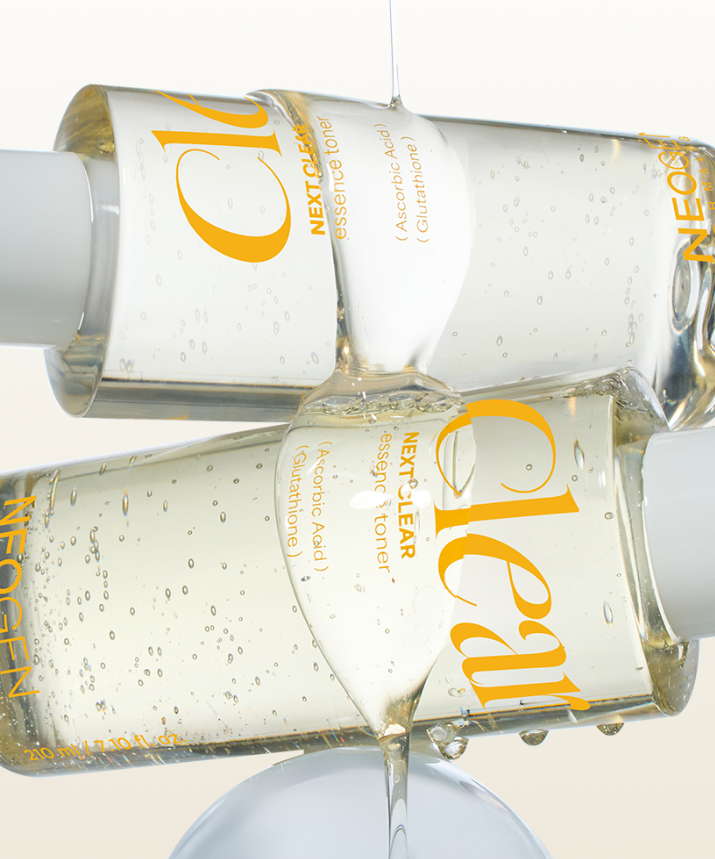 Two bottles of NEOGEN Next Clear Essence Toner 210ml with clear liquid, showcasing skincare product design and texture.