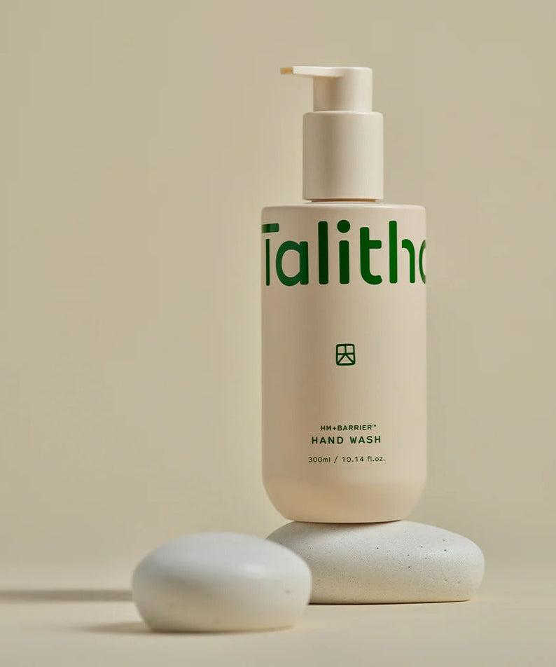 TALITHA KOUM HM+Barrier Hand Wash 300ml bottle on pebble-like stones, beige background, elegant skincare packaging