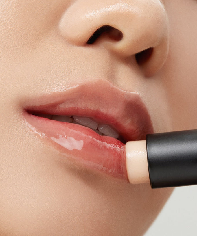 Applying TALITHA KOUM Lipcure Balmtik for moisturized, glossy lips