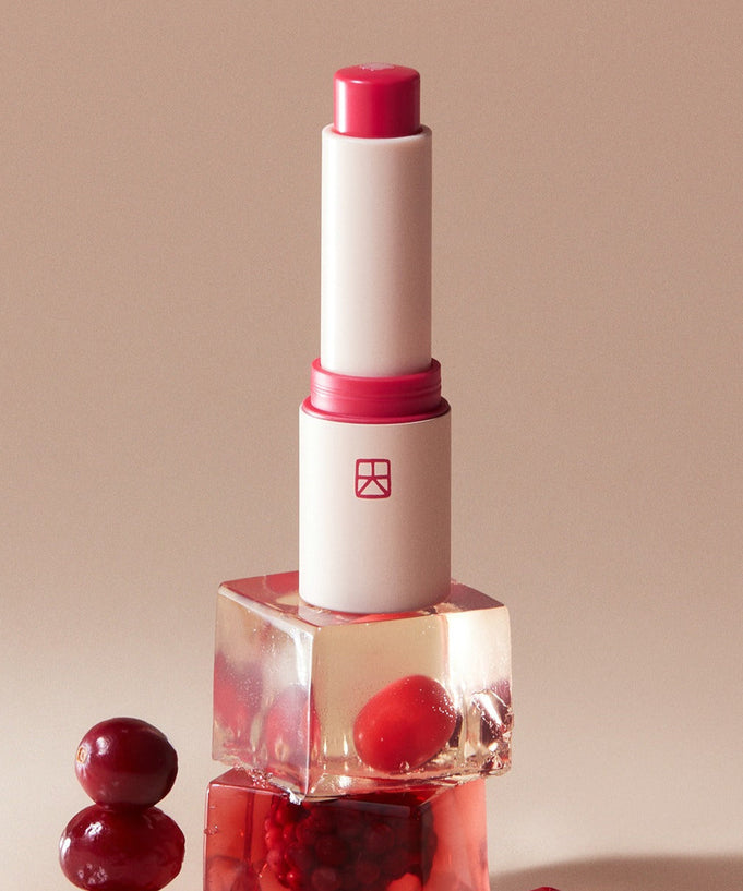 TALITHA KOUM Lipcure Balmtik displayed with fresh berries in a stylish arrangement.