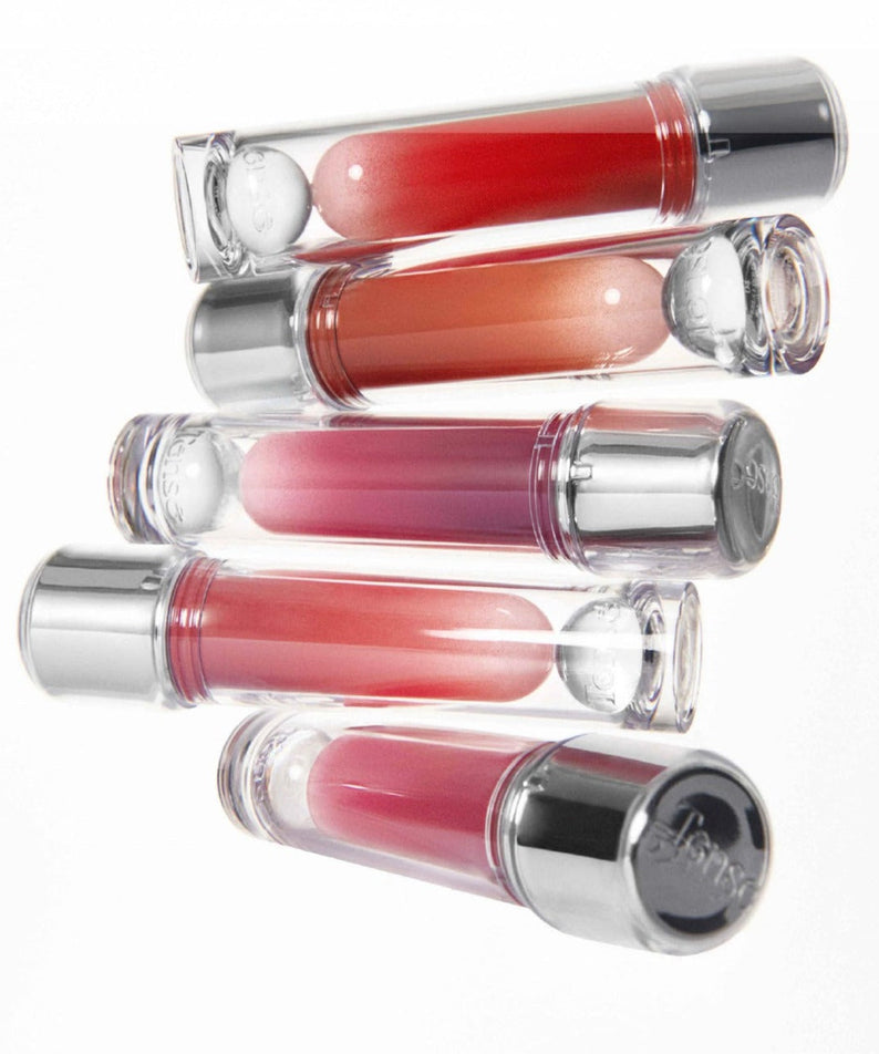 Variety of lip shades in TENSE Shine Moment Clossy Tint collection, featuring vibrant, glossy colors in transparent tubes with silver caps.