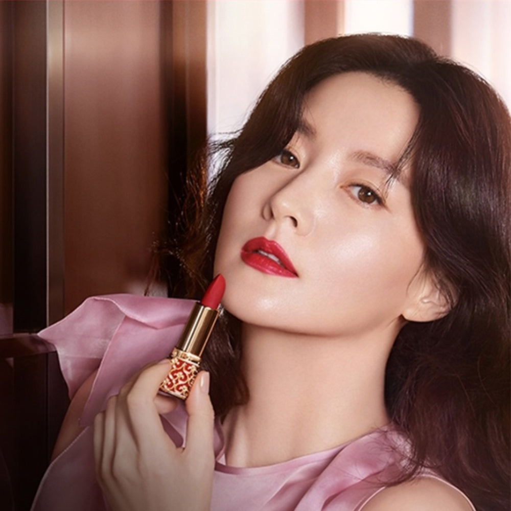 Model applying THE WHOO Gong Jin Hyang Mi Velvet Lip Rouge, showcasing vibrant lipstick color and luxurious packaging.
